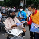 Fauzan Adima, Kepala Dinas Kesehatan Kota Kediri, turun langsung ikut membagikan alat promosi dan masker kepada pengguna jalan. foto: ist.