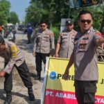 Petugas Polsek Sarirejo dan Tim Pekerja PT Ababil Widjaya saat melakukan perbaikan jalan rusak. 