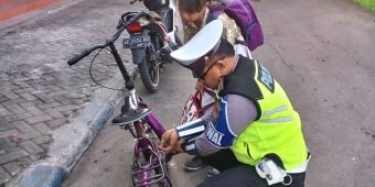Lakukan Pengamanan Pagi, Anggota Satlantas Polres Ngawi Betulkan Sepeda Pelajar