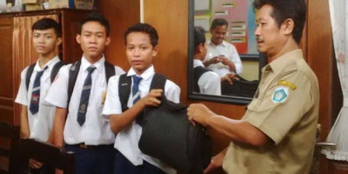 Pelajar mengembalikan tas yang ditemukannya. foto:aris sugiarto/BANGSAONLINE