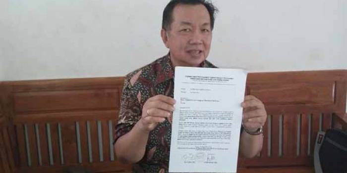 Go Tjong Ping saat menunjukkan surat gugatan yang ditujukkan kepada panitia dan penilik pemilihan pengurus masa bakti 2013-2016. foto: suwandi/BANGSAONLINE