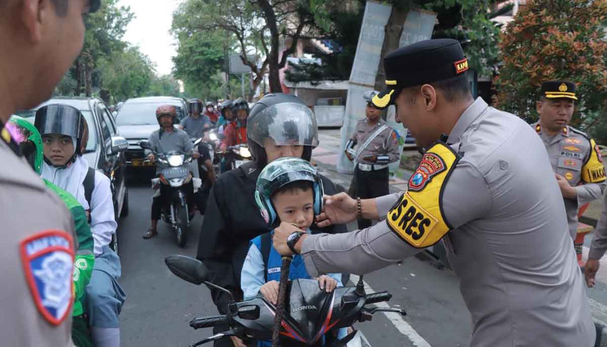 Petugas dari Satlantas Polres Blitar Kota saat membagikan helm serta cokelat ke salah satu pengendara pada Operasi Patuh Semeru 2025.