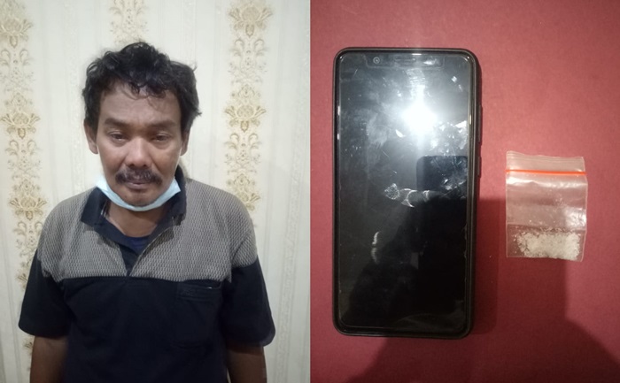 Tersangka berikut barang bukti sabu dan HP merek Vivo saat diamankan di Mapolres Pasuruan, Jumat (22/01).
