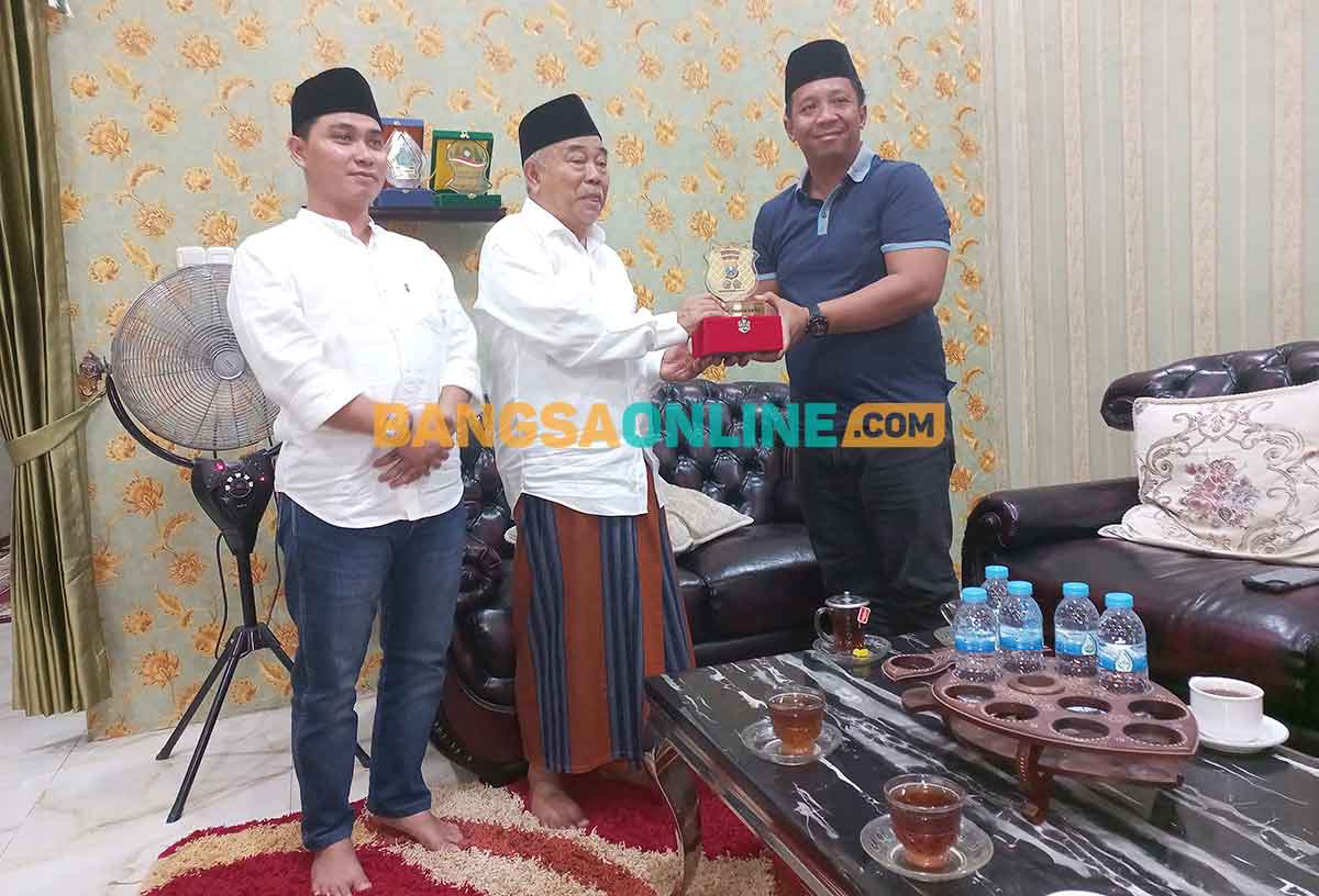Kiai Asep didampingi anaknya, Gus Barra, saat menerima cendera mata dari AKBP Apip Ginanjar. Foto: ROCHMAT SAIFUL ARIS/BANGSAONLINE
