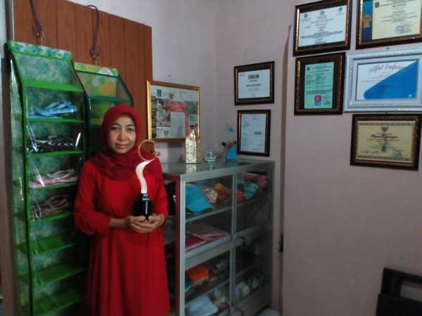 Erna dengan piala penghargaan yang diterimanya. foto: Fikma A/ BANGSAONLINE