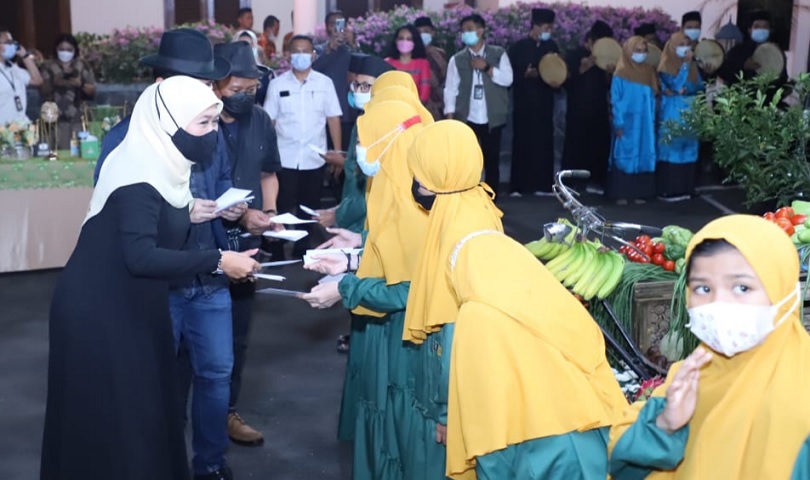 Gubernur Jawa Timur Khofifah Indar Parawansa  menyerahkan santunan pada anak yatim.