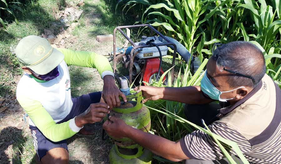 Paeran Al Sugeng Ariadi, Ketua Kelompok Tani Makmur Dusun Tegalsari, Desa Blimbing (kanan) dengan salah seorang petani saat memasang Tabung Gas Elpiji. (foto: MUJI HARJITA/ BANGSAONLINE)