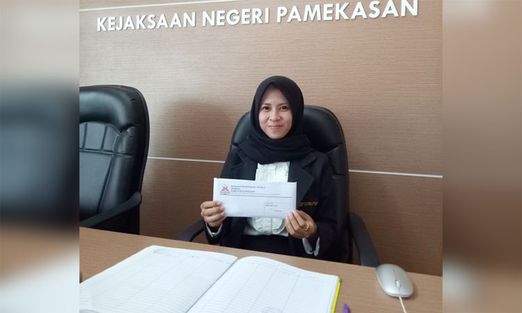 Resepsionis di lobi Kejari Pamekasan menunjukkan bukti penerimaan laporan dugaan pungli dana BOP TK di Kecamatan Pademawu yang diserahkan oleh LSM Komad, beberapa waktu lalu.