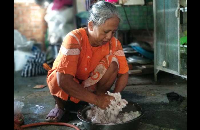 Siti Katidjah alias Ninik, pelaku home industri kue tradisional di Pacitan mengaku sepi omzet usai lebaran. foto: YUNIARDI S/ BANGSAONLINE