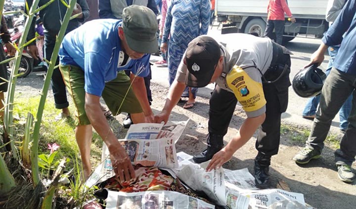 Petugas dibantu warga saat melihat kondisi jenazah korban.