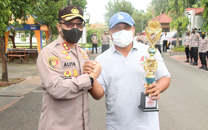 Kapolres Bangkalan, AKBP Alith Alarino, saat menyerahkan piala kepada Ketua AJB, Achmad Fauzi, di Mapolres Bangkalan.
