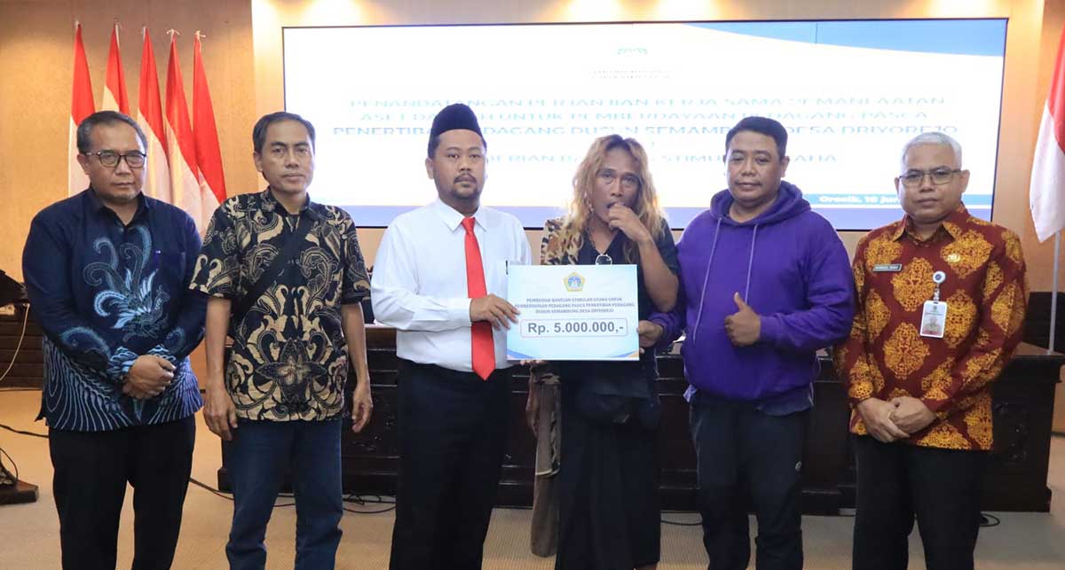 Bupati Gresik (tiga dari kiri) secara simbolis memberikan stimulan kepada Ali Candi selaku perwakilan PKL. Foto: Ist