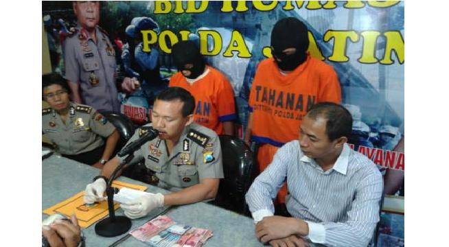 Dua pelaku beserta barang bukti berupa uang. (Rusmiyanto/BangsaOnline)