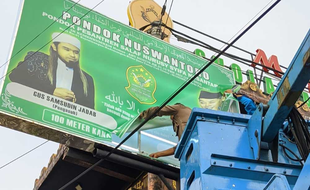 Petugas Satpol PP Kabupaten Blitar saat menurunkan salah satu baliho Samsudin.