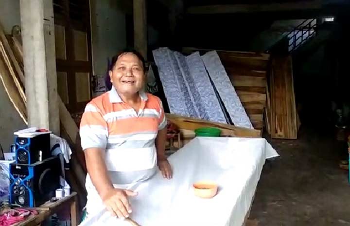 Suyadi saat membuat peti jenazah.