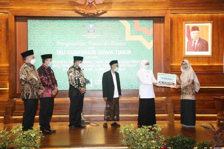 Gubernur Jawa Timur Khofifah Indar Parawansa saat menyerahkan bonos kepada salah satu perserta MTQ berprestasi di Gedung Negara Grahadi Surabaya, Kamis (4/2/2021). Foto: ist/bangsaonline.com