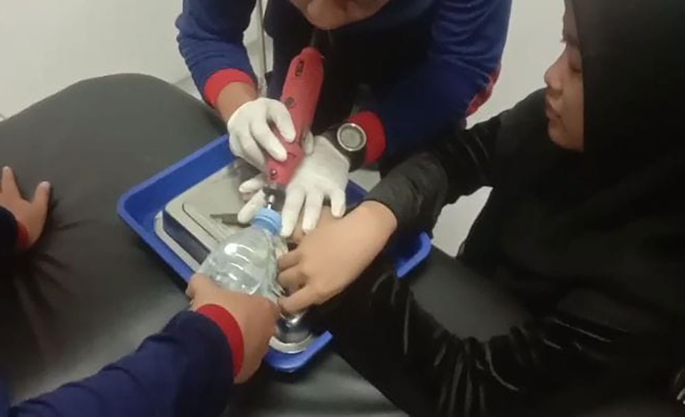Petugas saat berupaya melepas cincin yang nyangkut di jari korban.