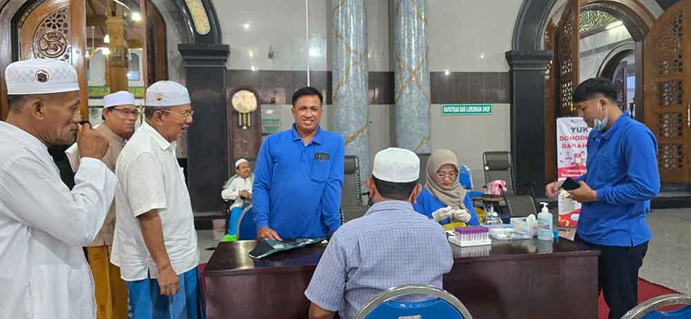 Para takmir Masjid Agung Bangkalan sedang melayani warga yang ingin mengecek kesehatan di Masjid Agung Bangkalan. (Ist)