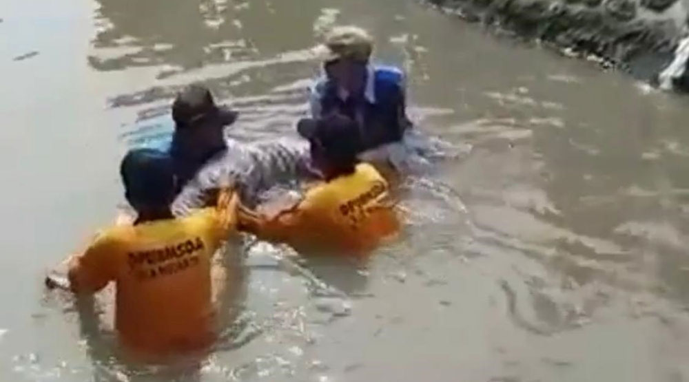 Petugas saat mengevakuasi jenazah kakek yang tenggelam di Sungai Desa Durungbedug, Kecamatan Candi, Sidoarjo.