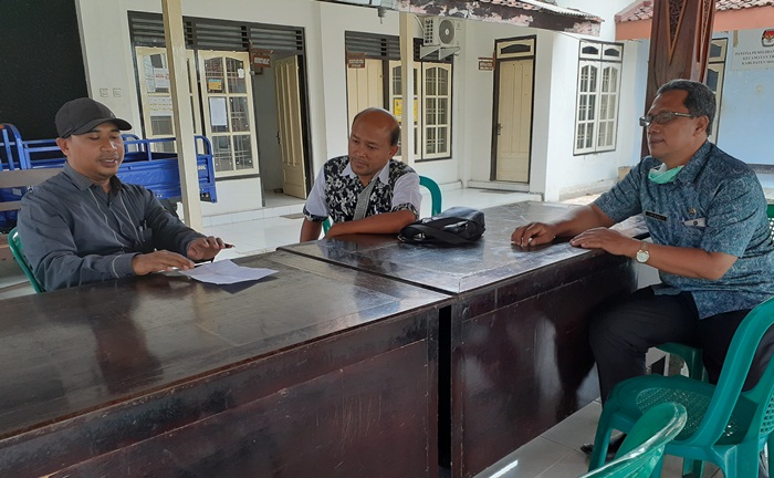 Dengan jarak lebih dari 1 meter, pegawai Disperindag Mojokerto memberi arahan kepada kepala desa mengenai ditundanya sosialisasi Tera bagi masing-masing PKK di setiap desa.