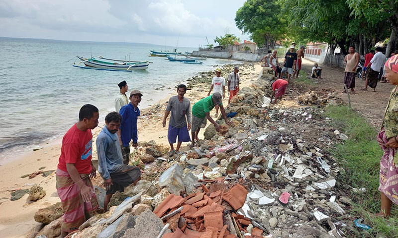 Warga Pesisir Desa Bringsang, Kecamatan Giligenting, Sumenep, saat bergotong royong memperbaiki jalan yang rusak.