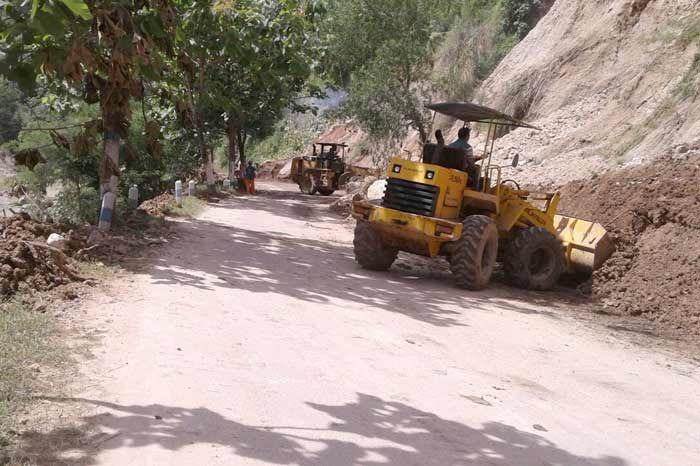 Alat berat melakukan proses pembersihan lokasi longsor di jalur Pacitan - Ponorogo.