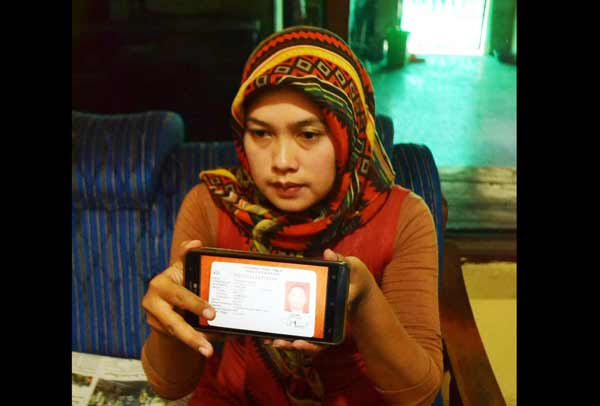 Istiana menunjukkan foto KTP suamianya. Foto: agus/BANGSAONLINE
