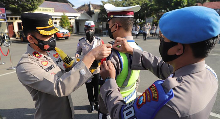 Wakapolres Kediri, Kompol Hendry Ibnu Indarto, saat menyematkan pita kepada salah satu petugas. Foto: Ist