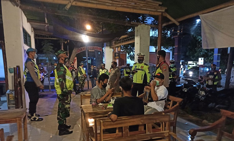Petugas Gabungan TNI, Polri, dan Satpol PP Kota Kediri saat mendapati pengunjung warung yang tak mengindahkan protokol kesehatan, yaitu jaga jarak. (foto: ist).