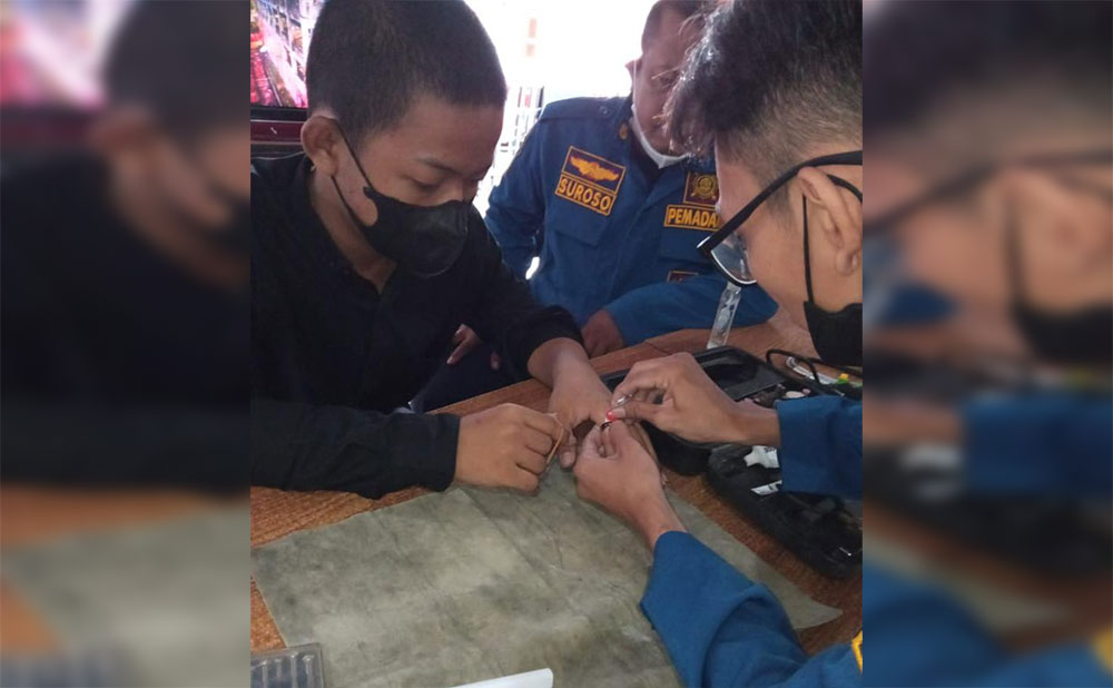 Proses pelepasan cincin di jari Adek Ahmad oleh Petugas Damkar Gresik. foto: ist.