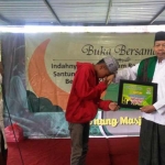 Ahmad Tegar (13), warga Cemorokandang saat menerima santunan dari Ust. Neyluk Izdiran, disaksikan Ketua Baznas Kota Malang. foto: IWAN/ BANGSAONLINE