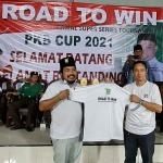 Pengurus DPC PKB Bangkalan Khotib Marzuki, memberikan cendera mata berupa kaos kepada Ketua PBSI Bangkalan Rachmat Basuki, sebagai tanda dimulainya Turnamen Bulutangkis PKB Cup di Gor Nusantara, Tanjung Jati, Kecamatan Kamal, Bangkalan, Jumat (1/10/2021) malam.