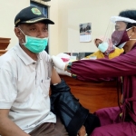 Guswanto saat divaksin tahap II di Aula Gedung DPRD Trenggalek. foto: HERMAN/ BANGSAONLINE