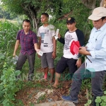 Petugas saat menunjukkan salah satu patok yang dirusak warga.