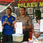 Kapolres Malang AKBP Yade Setiawan Ujung menunjukkan barang bukti OTT kades Kalisongo. 