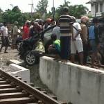 warga berkerumun melihat ringseknya bodi mobil usai dihajar KA. foto:eky nur hadi/BANGSAONLINE