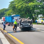 Kondisi mobil Wuling yang terguling di Tol Sidoarjo sebelum dievakuasi petugas.