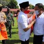 Wakil Bupati Jombang, Sumrambah saat memakaikan rompi kepada salah satu kepala desa. (foto: AAN AMRULLOH/ BANGSAONLINE)