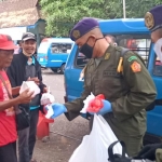 Anggota Satuan Resimen Mahasiswa 836/Macan Putih Universitas Islam Malang saat melakukan kegiatan bagi-bagi masker gratis secara terpusat di Terminal Landungsari, Kota Malang.