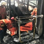 Petugas PMK Surabaya melakukan evakuasi dan pembasahan kebakaran SPBU Brebek Industri. 