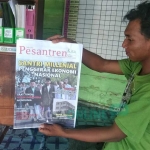 Syamsul, pengurus Pesantren Mansyahul Huda menunjukkan tabloid Pesantren Kita yang dikirim seseorang.