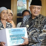 Bupati Sanusi saat memberikan bantuan.