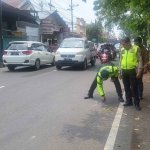 Petugas saat olah TKP di Jalan Raya Lebo, Sidoarjo.