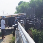 Kondisi truk kontainer yang nyaris kejebur sungai. foto: Aan Amrulloh/ BANGSAONLINE