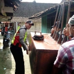 Petugas saat membawa barang bukti berupa alat yang dipakai produksi arak. 