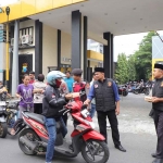 Petugas dari Polres Kediri saat membagikan takjil ke masyarakat.