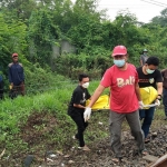 Petugas saat mengevakuasi Mr X yang tewas tersambar kereta api di depan bekas pabrik PT Soda Sidoarjo.