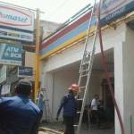 HANGUS. Petugas PMK sedang berupaya menjinakkan api yang melahap gudang mini market. foto: catur andy/BANGSAONLINE