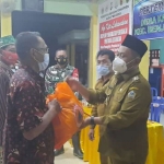 Bupati Gresik Gus Yani didampingi Kepala BPBD Tarso Sagito, dan Camat Benjeng Suryo Wibowo saat memberikan bantuan sembako kepada korban banjir luapan Kali Lamong di Desa Karangankidul Kecamatan Benjeng. foto: SYUHUD/ BANGSAONLINE