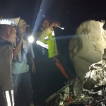 Petugas saat mengidentifikasi mobil yang ringsek usai mengalami laka dengan KA Sembrani